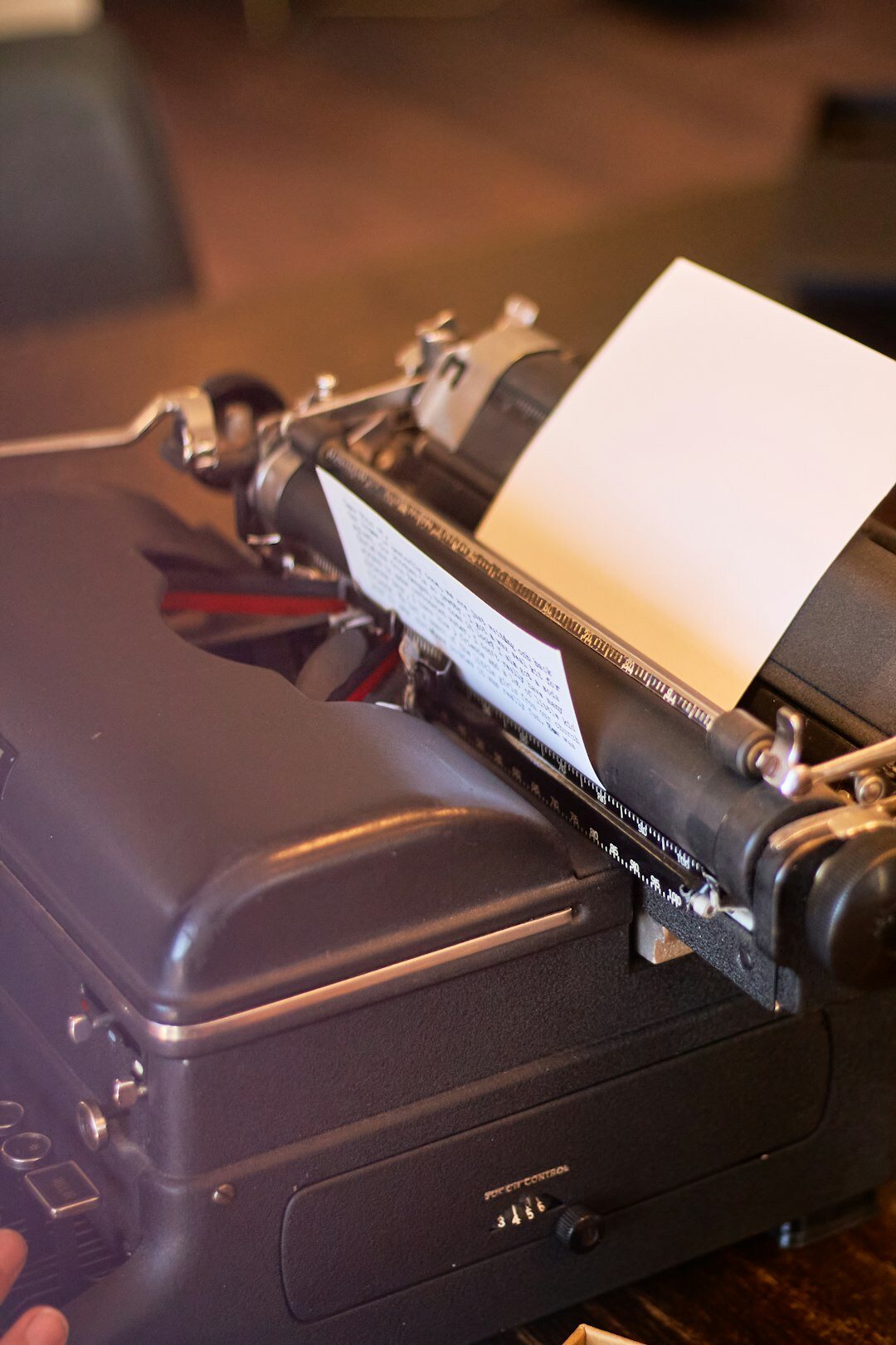 Vintage typewriter with a blank page and scattered notes on a desk