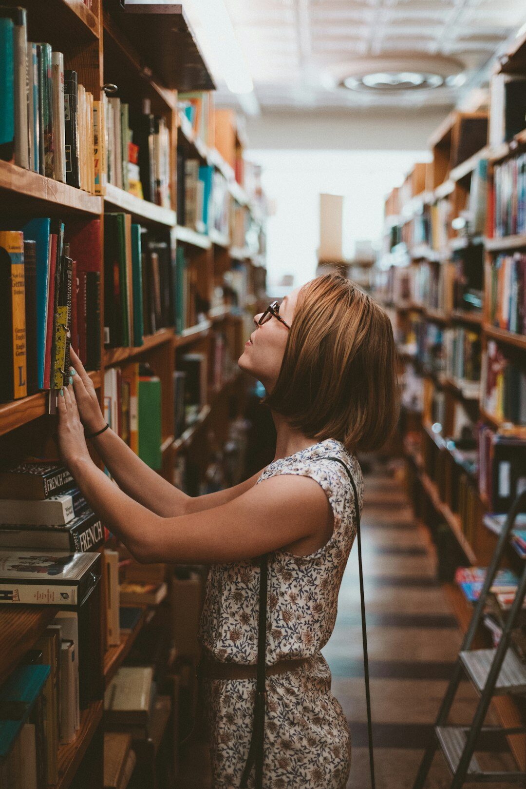 Croatian author standing in a dim study lined with books